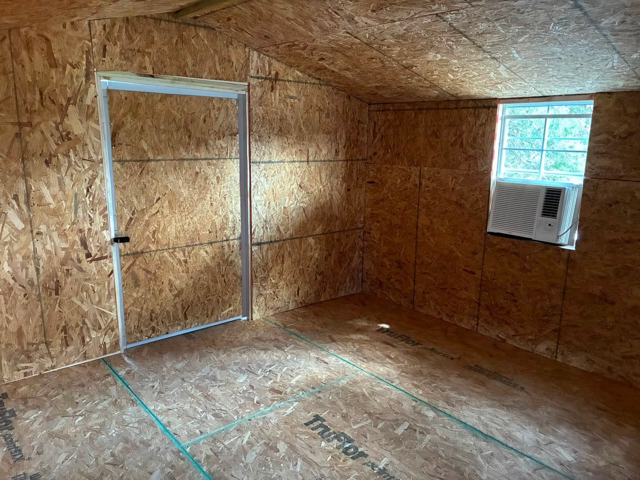 Interior corner of the walk-in doghouse showing the cooling unit and entry door