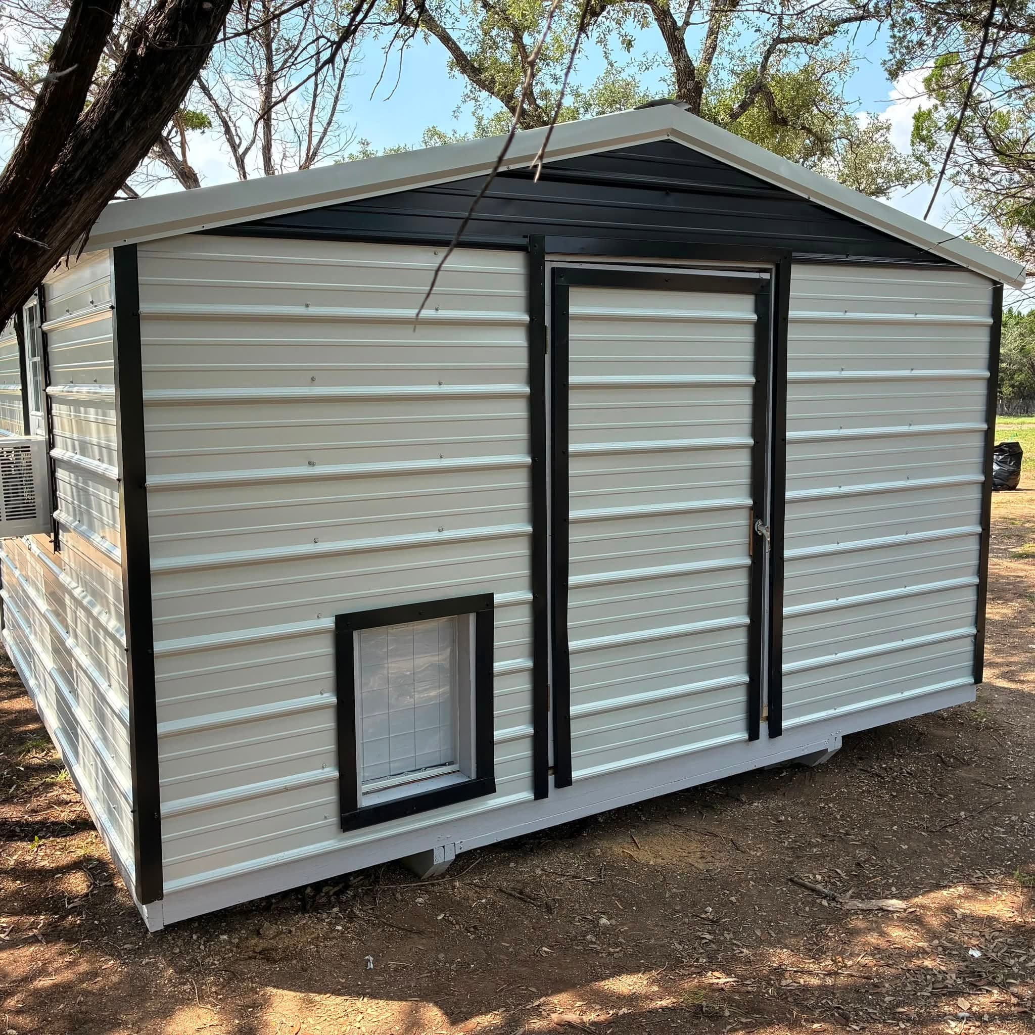 Front and side exterior of the walk-in doghouse with pet door and window air conditioner