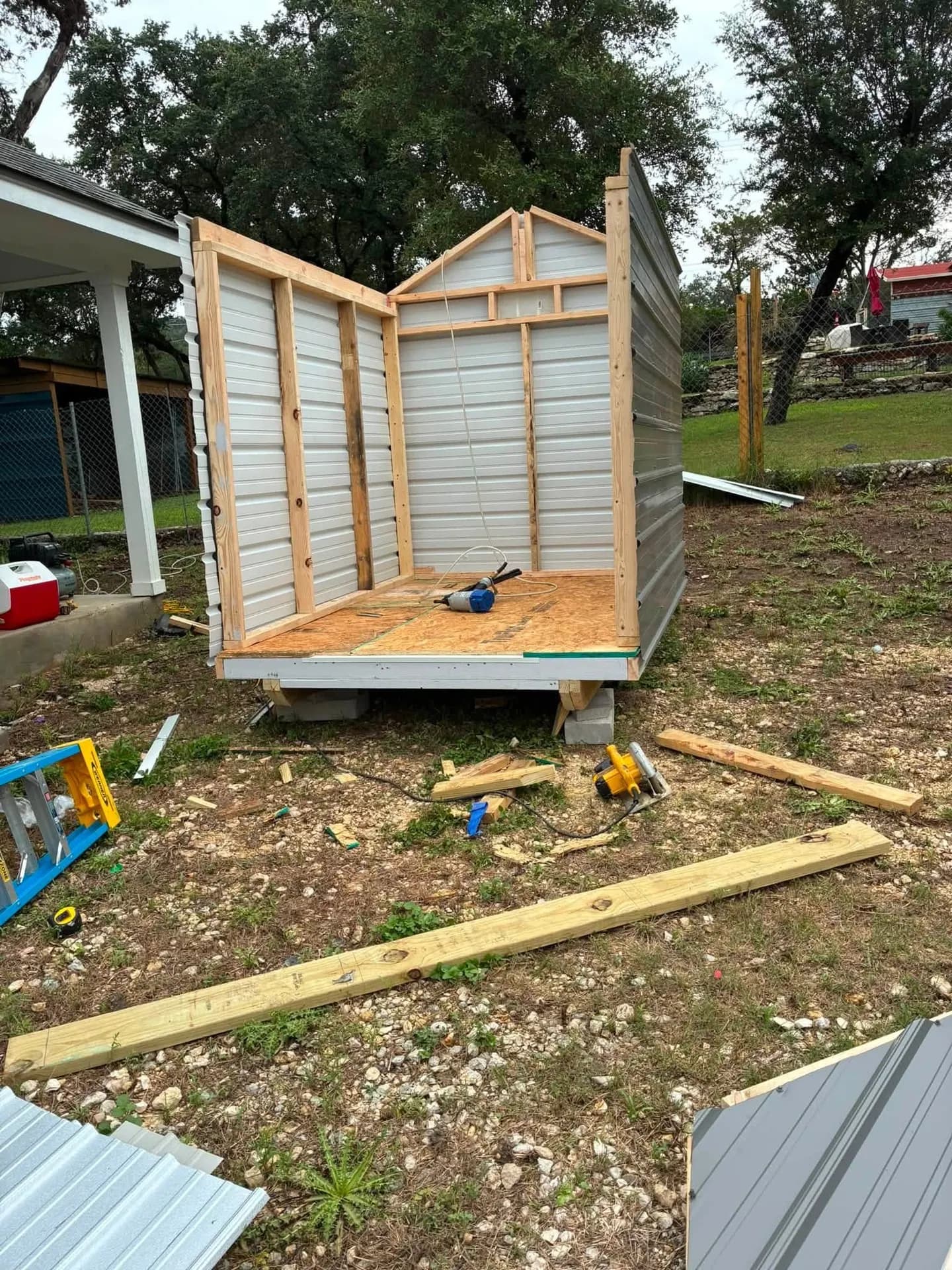 Shed walls framed with treated lumber during on-site build in a Lakehills, TX backyard
