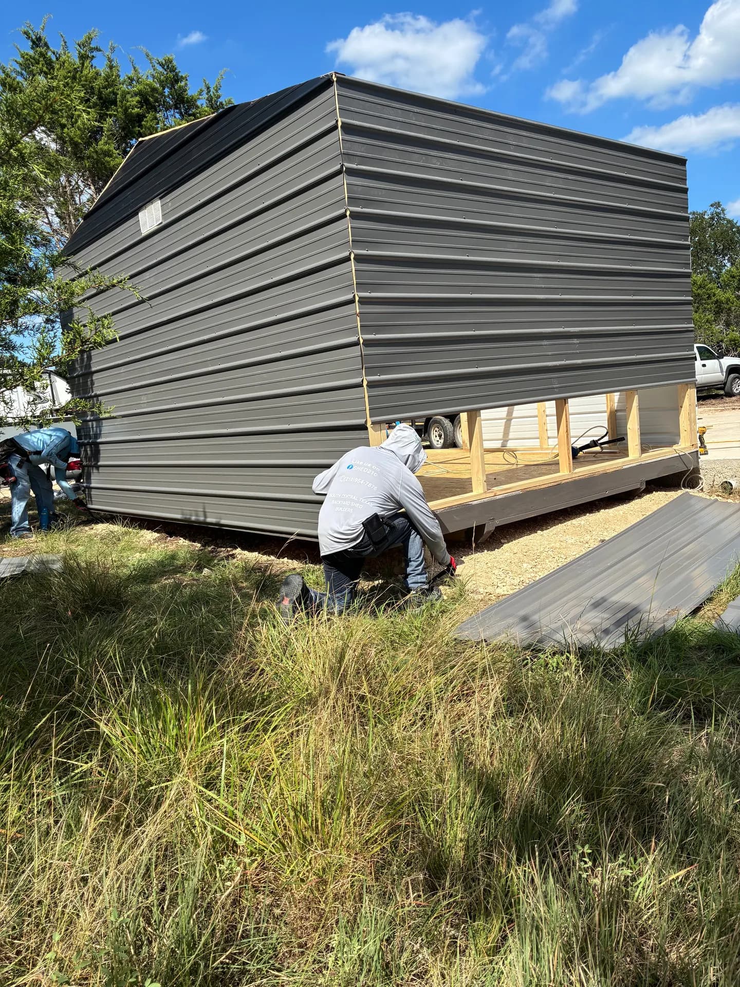 Shed210 crew installing gray metal siding over the framed heavy-duty floor base during the Boerne build