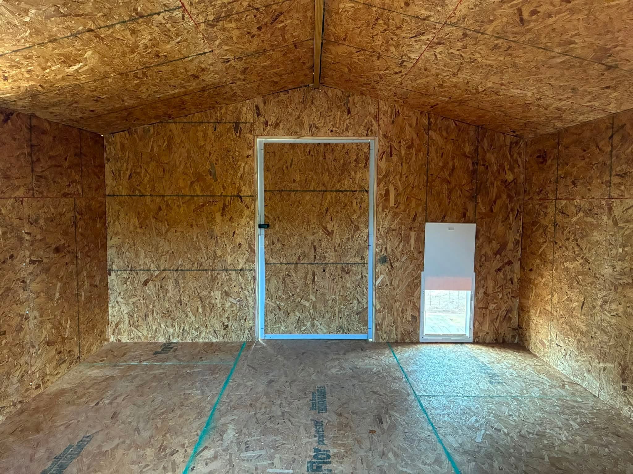 Interior of the walk-in doghouse showing the porch entry and pet door