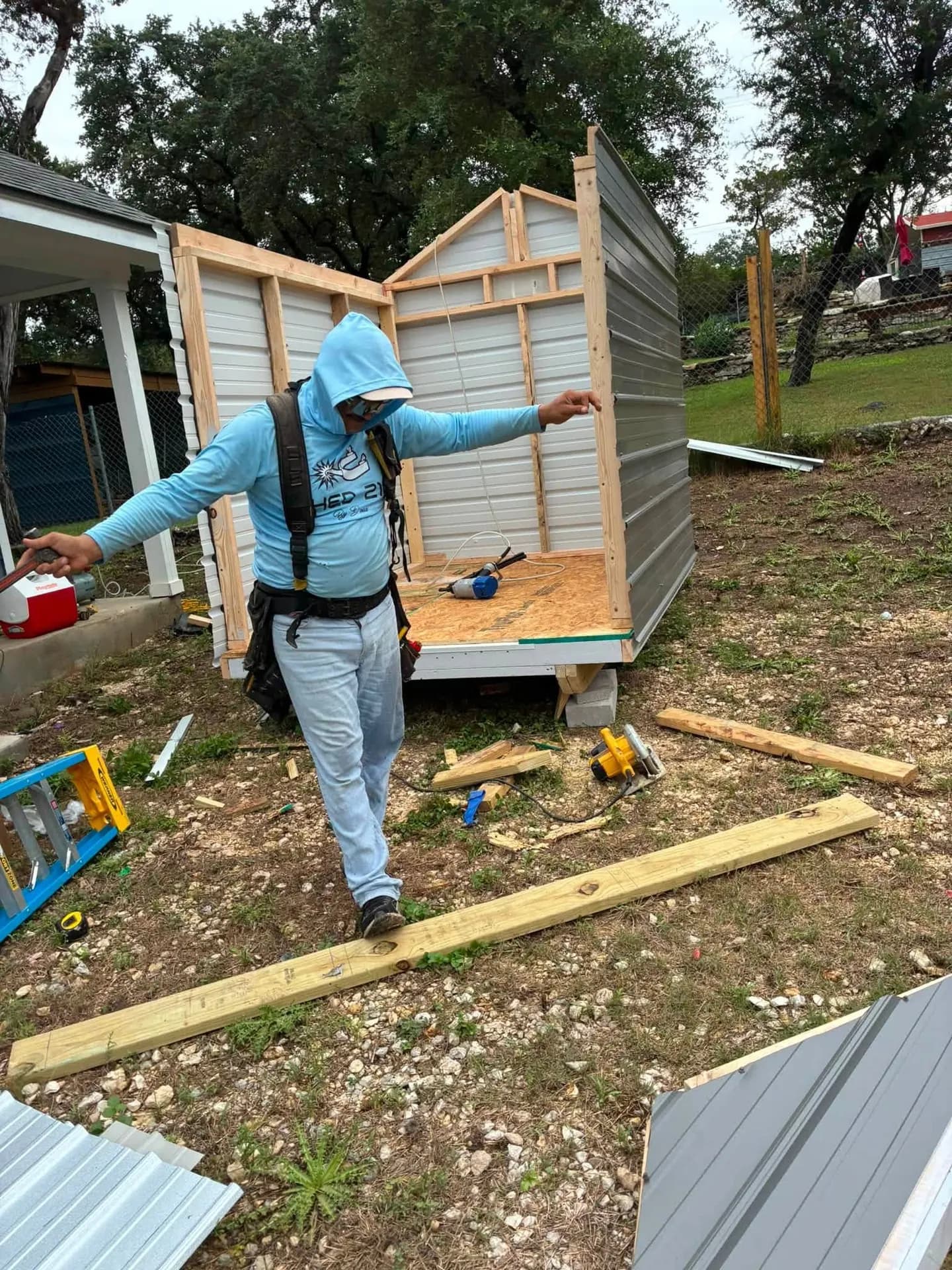 Shed 210 crew member framing a custom metal shed on-site in Lakehills, TX