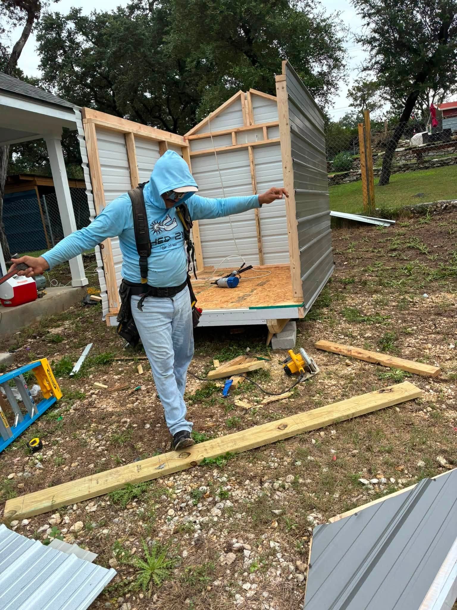 Shed 210 crew member framing a custom metal shed on-site in Lakehills, TX