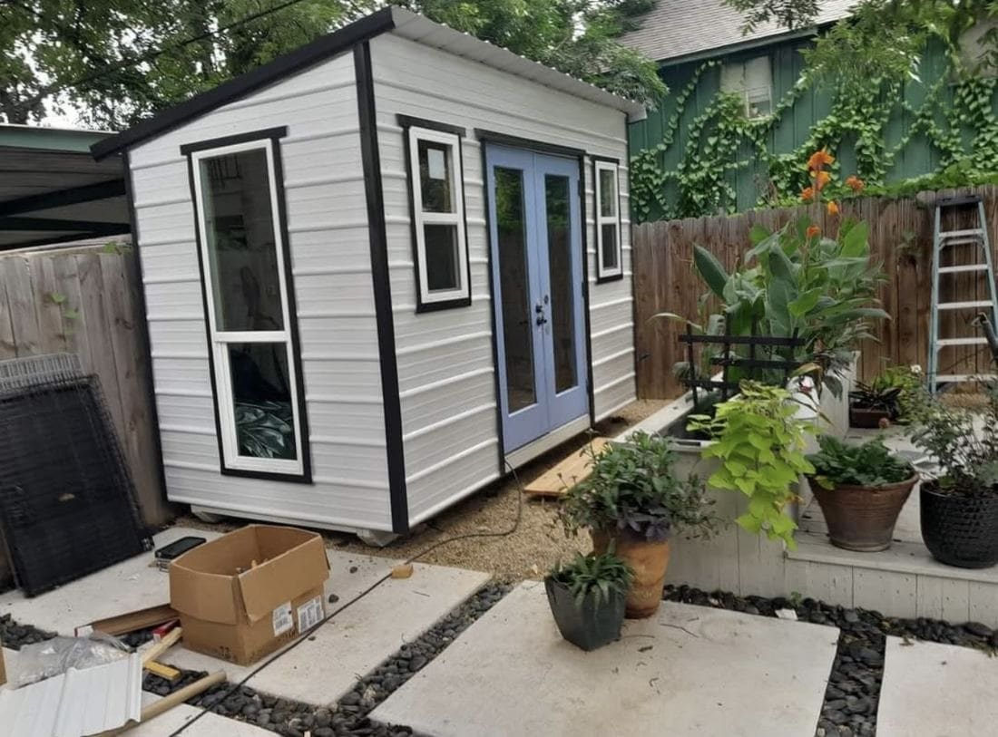 One-day custom shed installation with painted exterior and metal roof near Schertz, Texas.